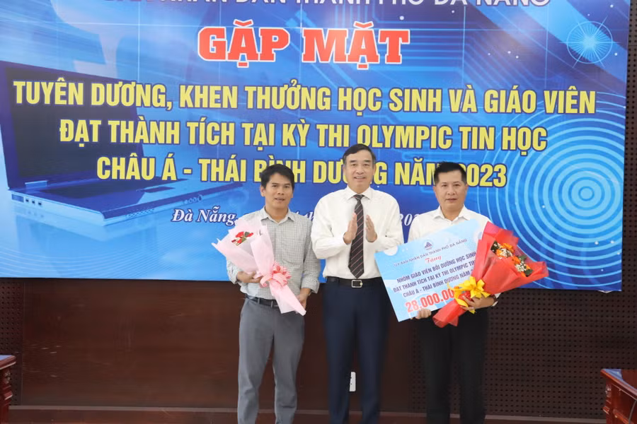 Ông Lê Trung Chính, Chủ tịch UBND TP Đà Nẵng tặng hoa chúc mừng nhóm giáo viên tham gia công tác bồi dưỡng, hướng dẫn cho em Lê Ngọc Bảo Anh.