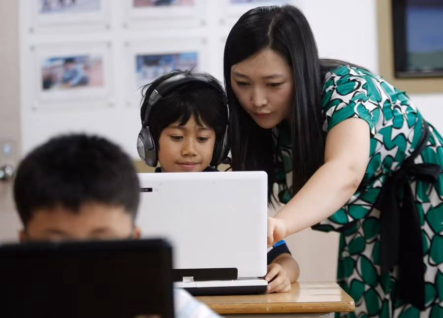 Giáo viên Hàn Quốc hướng dẫn học sinh sử dụng máy tính xách tay. Giáo viên Hàn Quốc hướng dẫn học sinh sử dụng máy tính xách tay.