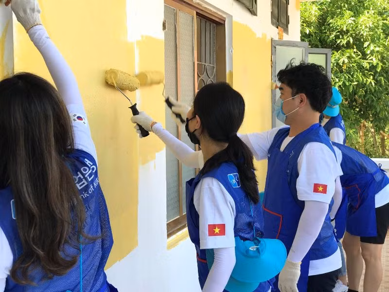 Các cán bộ ngân hàng IBK (Hàn Quốc) cùng các thầy cô giáo và các em học sinh trường Tiểu học và THCS Phú Cường tham gia sơn lại trường, lớp học