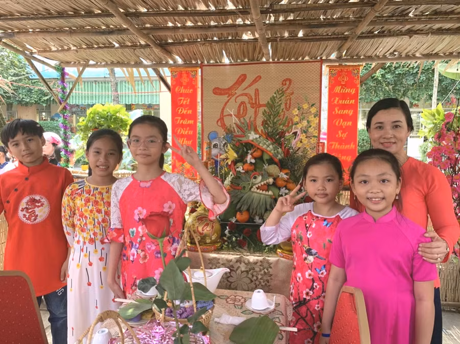 Giáo viên và học sinh chụp hình lưu niệm bên mâm cỗ ngày xuân.