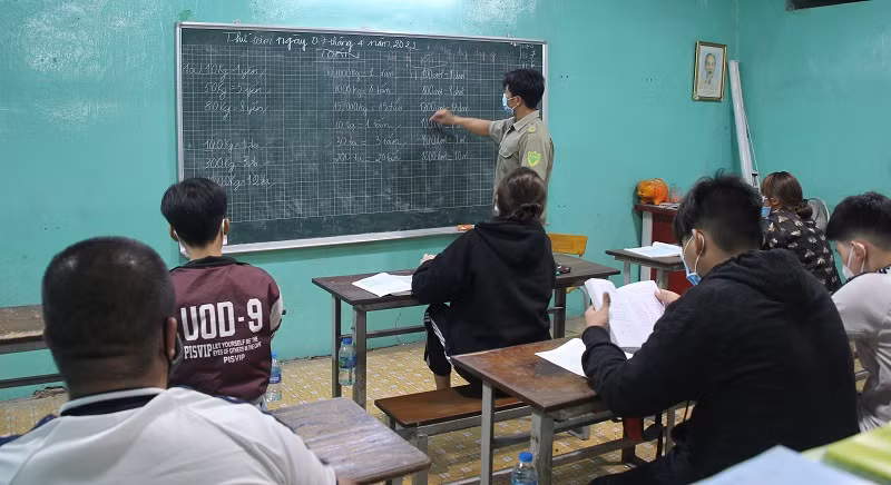 Anh Trần Lâm Thắng dạy các em học sinh đang học lớp 4 tại lớp học tình thương.
