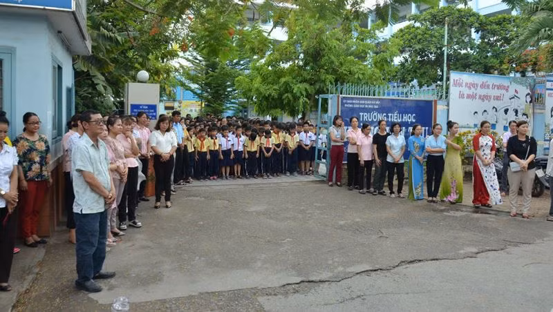 Học sinh, giáo viên Trường Tiểu học Hoàng Văn Thụ (quận Gò Vấp) đứng trước cổng tiễn biệt thầy Hiệu trưởng khi linh cữu thầy đi qua trường. Ảnh: Báo Pháp Luật Việt nam