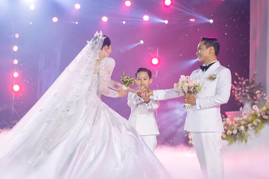Cặp đôi cùng cậu con trai cưng tiến lên lễ đài để thực hiện các nghi thức của buổi lễ.