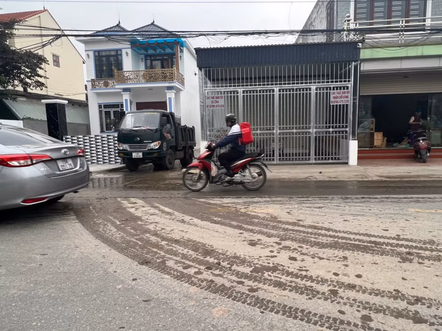 Xe chở bùn thải đi san lấp nhà dân.