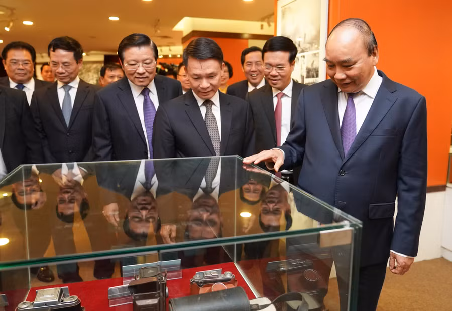 Thủ tướng Nguyễn Xuân Phúc và các đại biểu tham quan Phòng truyền thống của TTXVN. - Ảnh: VGP/Quang Hiếu