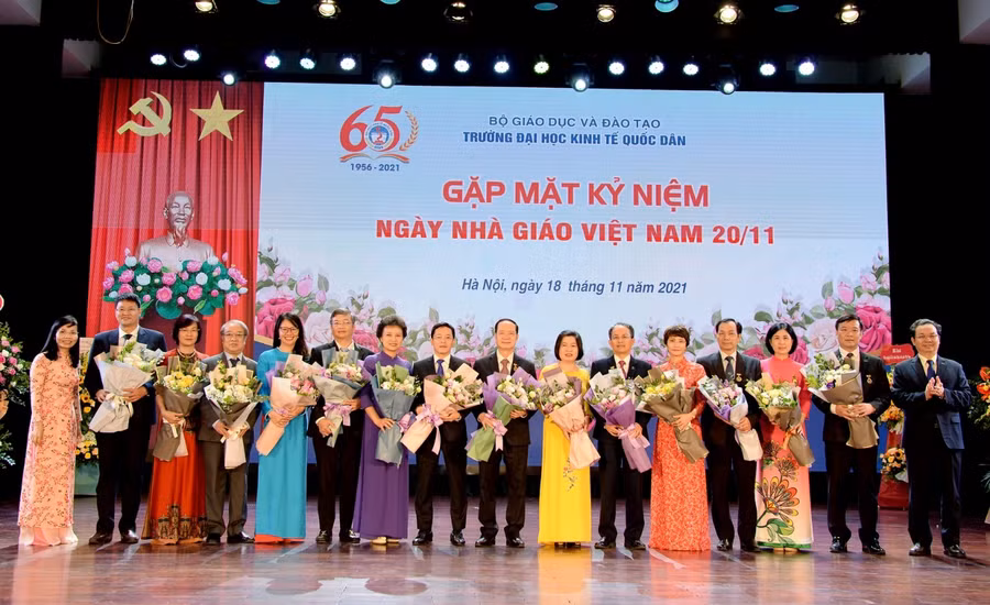 GS.TS. Hoàng Văn Cường - Phó Hiệu trưởng và GS.TS Trần Thị Vân Hoa - Phó Hiệu trưởng tặng hoa chúc mừng 14 Nhà giáo Ưu tú được phong tặng danh hiệu năm 2021.