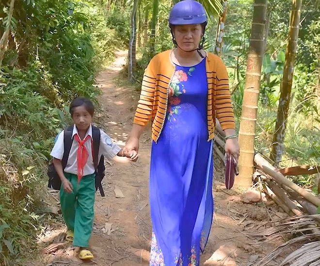Khít là một học sinh khuyết tật được cô Võ Thị Thanh Thủy - Hiệu phó Trường Tiểu học số 2 Di Lăng - đỡ đầu