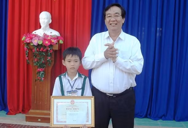 Phó GĐ Sở GD&ĐT Cà Mau Lê Thanh Liêm trao bằng khen của Bộ trưởng Bộ GD&ĐT Phùng Xuân Nhạ cho em Nguyễn Nhựt Nam