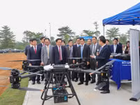 Phó Thủ tướng Hồ Quốc Dũng, Bộ trưởng Bộ GD&ĐT Hoàng Minh Sơn cùng các quan khách thăm quan khu thử nghiệm UAV của Đại học Quốc gia Hà Nội. Ảnh: VNU.