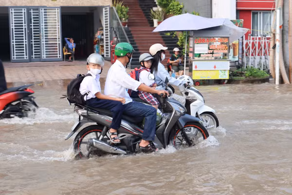 Phụ huynh ở Cần Thơ đưa con đến trường trong mùa triều cường. Ảnh: T.P