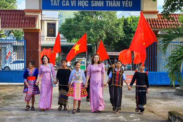 Học sinh miền núi Đắk Lắk đến trường trong vòng tay thầy cô. Ảnh tư liệu