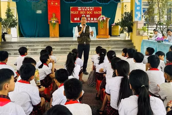 Tác giả nói chuyện về đọc sách cùng học sinh Trường Tiểu học Vinh Hưng trong ngày hội đọc sách. Ảnh: NVCC