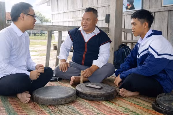 Nghệ nhân Đinh Hdot hướng dẫn Bùi Thành Luân và Y Sơn Việt cách chỉnh chiêng truyền thống.