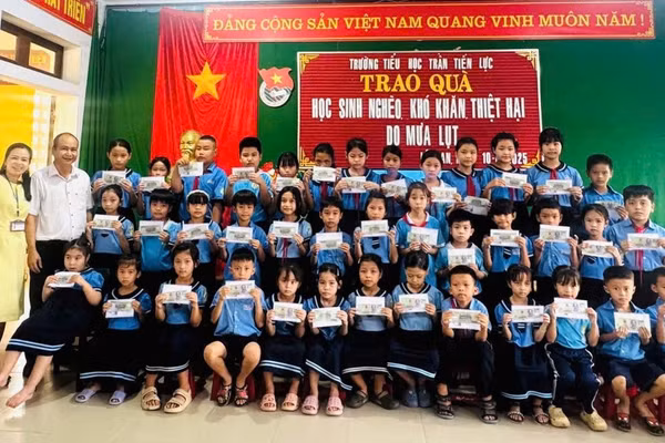 Tác giả thay mặt nhà hảo tâm tặng quà sau lụt cho học sinh bị thiệt hại sau cơn lũ cuối tháng 10 tại Trường Tiểu học Trần Tiến Lực, TP Huế. Ảnh: NVCC