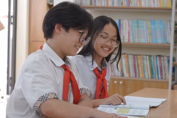 Học sinh Trường THCS Bế Văn Đàn (phường Quang Trung, Hà Nội) trao đổi bài học trong SGK. Ảnh: Xuân Phú
