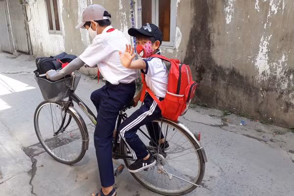 Hai anh em đến trường. Ảnh: NVCC