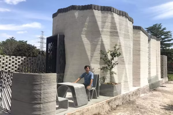 PGS.TS Trần Văn Miền bên ngôi nhà được tạo bằng công nghệ in 3D. Ảnh: NVCC