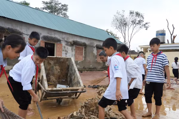 Học sinh Trường THCS Kỳ Tân, xã Tân Kỳ, Nghệ An tham gia dọn dẹp, vệ sinh sân trường sau lũ. Ảnh: Hồ Lài