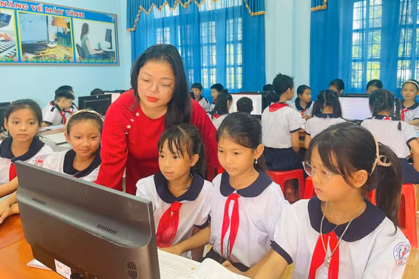 Cô giáo Trần Thị Huệ hướng dẫn học sinh thực hành môn Tin học. Ảnh: Đăng Đức