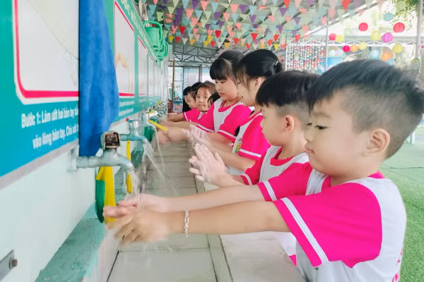 Học sinh Trường Mầm non Nắng Hồng (phường Hòa Thành, Cà Mau) được hướng dẫn rửa tay sau khi đi vệ sinh. Ảnh: QM