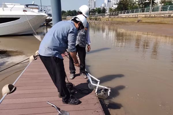 Thu mẫu bùn tại nhà máy giấy để phân tích trong đề tài nghiên cứu. Ảnh: NVCC