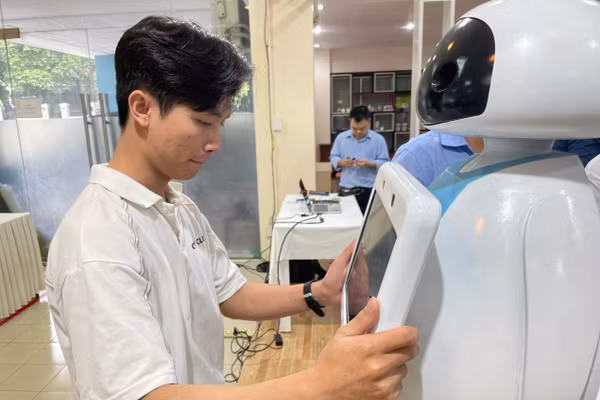 Robot lễ tân do PGS.TS Đặng Xuân Ba và cộng sự nghiên cứu được vận hành bên lề một hội thảo để lấy ý kiến góp ý từ các chuyên gia. Ảnh: Hà An