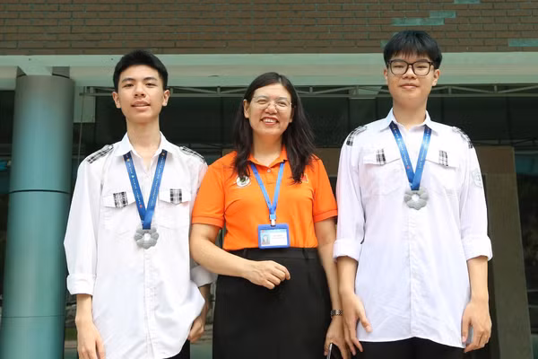 Cô giáo Đào Hải Yến chúc mừng Phùng Quang Hưng và Thân Đức Chính sau khi hai em giành Huy chương Bạc Olympic Sinh học quốc tế.