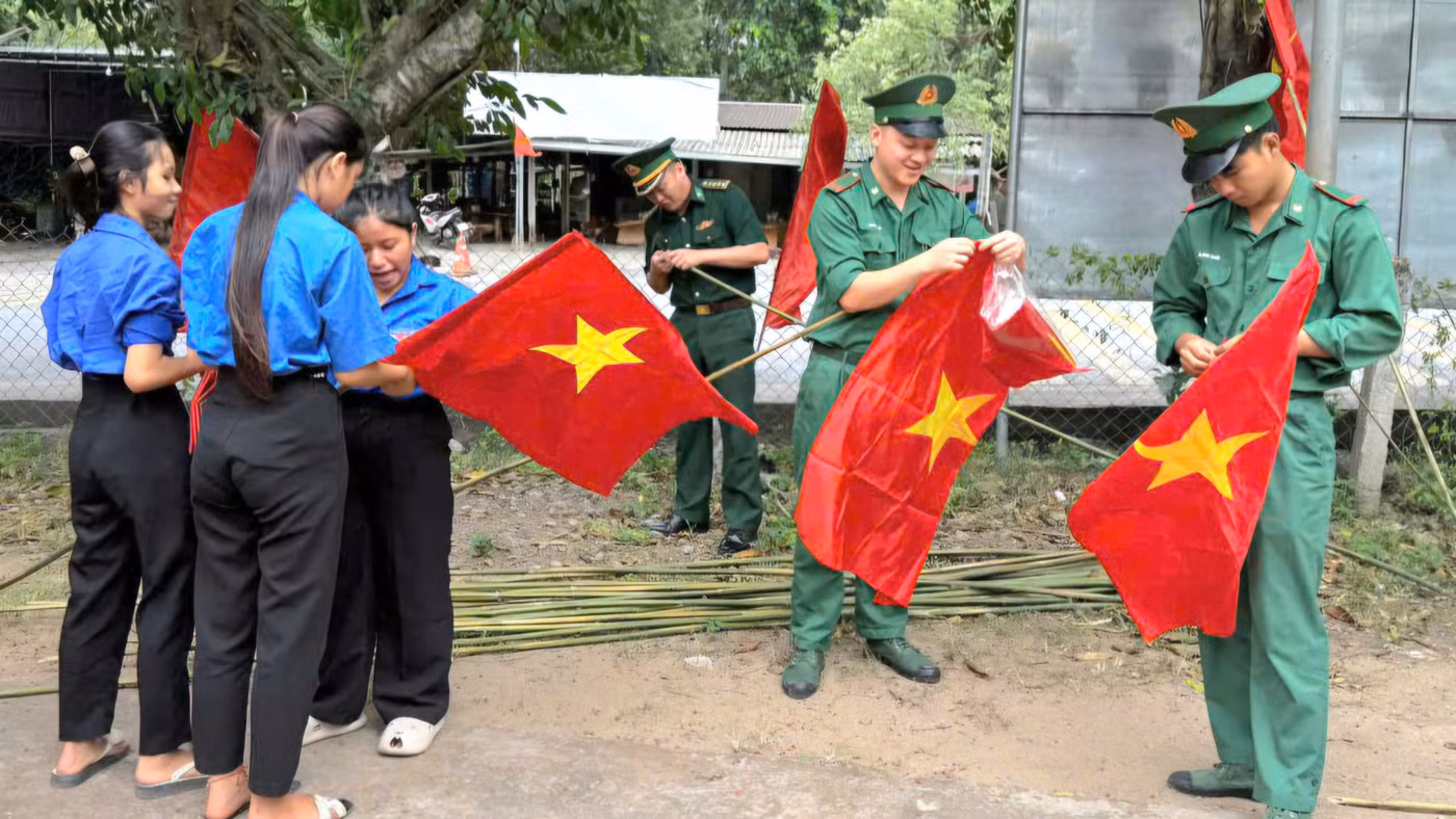 Bộ đội Biên phòng Quảng Trị cùng đoàn viên thanh niên treo cờ ở các tuyến đường.