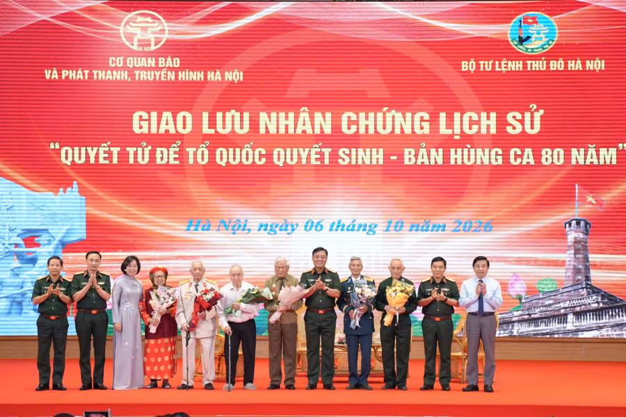 Đại diện Ban tổ chức chương trình tặng hoa, chụp ảnh với nhân chứng lịch sử.