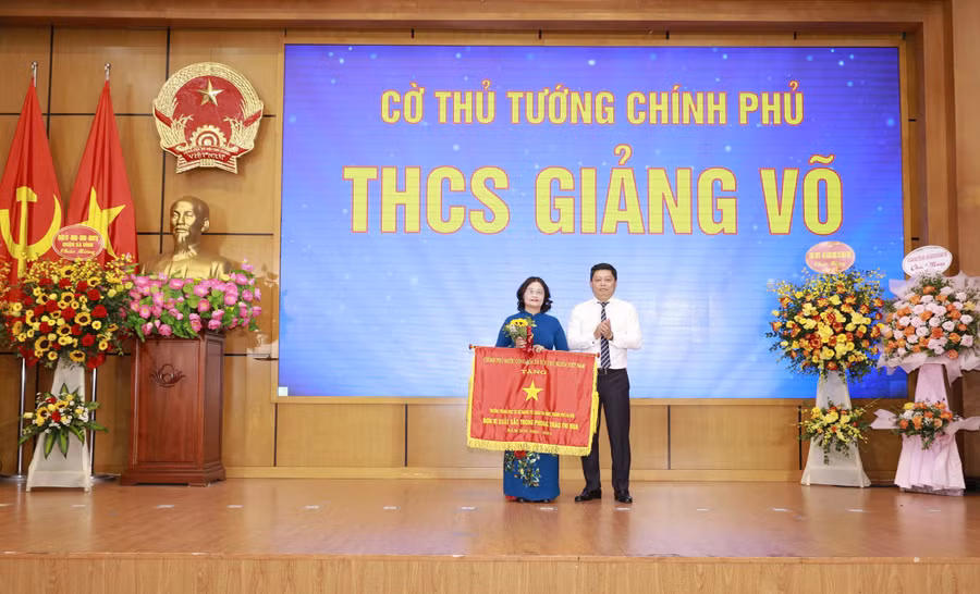 Thừa ủy quyền, Chủ tịch UBND quận Ba Đình Tạ Nam Chiến trao Cờ thi đua Chính phủ cho đại diện Trường THCS Giảng Võ.