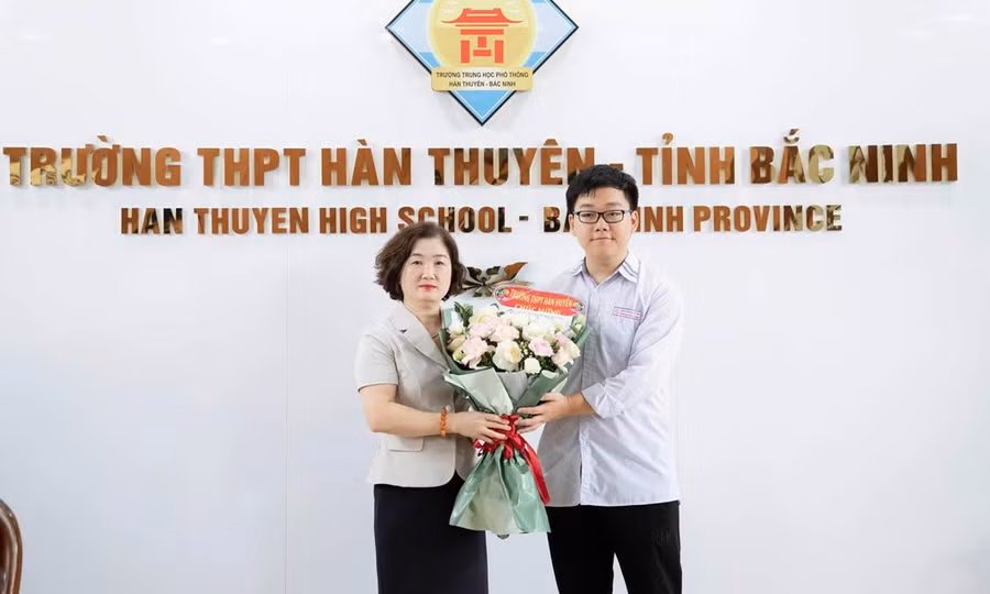 Nhà giáo Đặng Thị Bích Vân - Hiệu trưởng Trường THPT Hàn Thuyên chúc mừng em Lê Minh Đức.