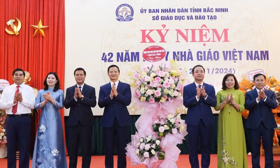 Chủ tịch UBND tỉnh Bắc Ninh Vương Quốc Tuấn (thứ 4 từ trái qua) cùng đại biểu tặng hoa chúc mừng ngành GD&ĐT.