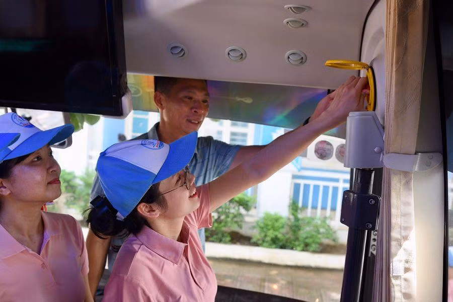 Giáo viên tập huấn kỹ năng thoát hiểm trên xe ô tô đưa đón học sinh.