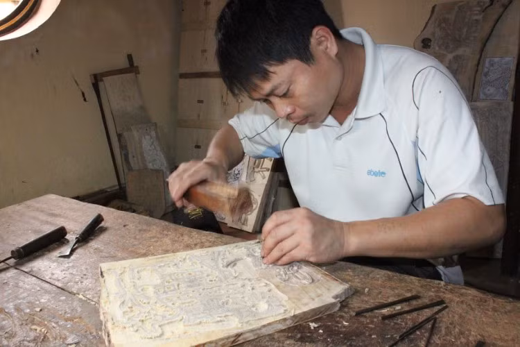 Thợ khắc mẫu trên bản gỗ.