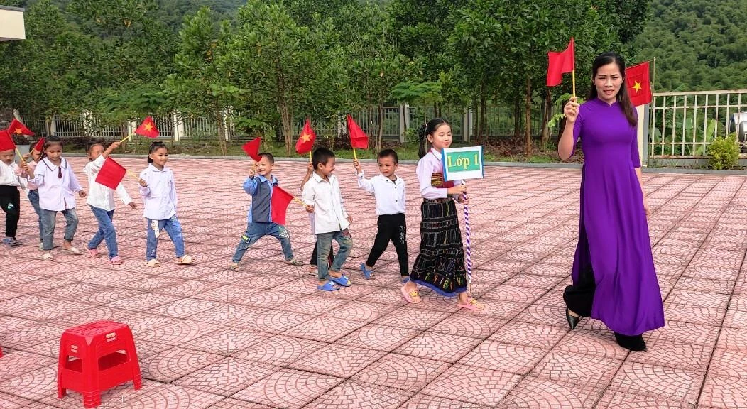 Cô giáo đón học sinh vào lớp 1 ở điểm trường Sa Ná (Na mèo, Quan Sơn, Thanh Hóa).