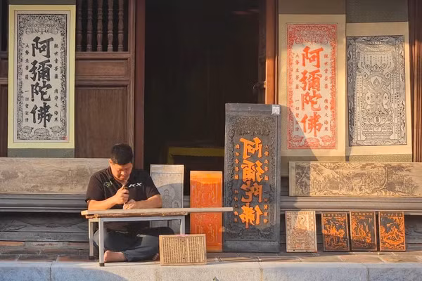 Nghệ nhân Nguyễn Công Đạt khắc bộ tranh tại chùa Vĩnh Nghiêm.