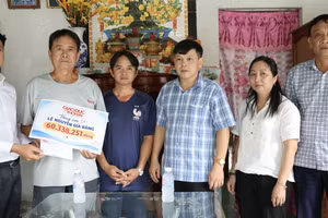 Báo GD&TĐ trao số tiền bạn đọc ủng hộ cho gia đình Lê Nguyễn Gia Bằng trước sự chứng kiến của Chủ tịch UBND phường Long Mỹ, ông Nguyễn Minh Hiền (thứ tư từ trái sang) và bà Lý Lệ Hoa, Phó Chủ tịch Ủy ban MTTQ Việt Nam - Chủ tịch Hội Nông dân phường.