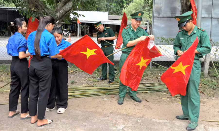 Bộ đội Biên phòng Quảng Trị cùng đoàn viên thanh niên treo cờ ở các tuyến đường.
