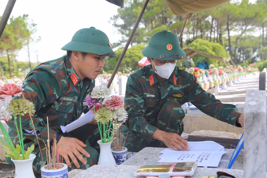 Lực lượng chức năng thực hiện quy trình lấy mẫu hài cốt liệt sĩ.