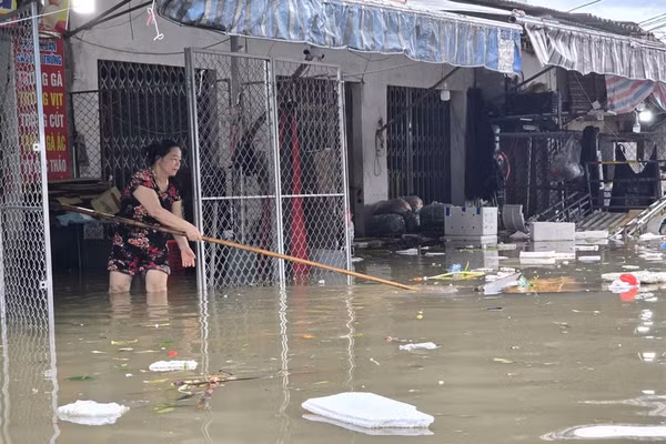 Tiểu thương chợ Vinh di dời hàng hóa đến nơi khô ráo. (Ảnh: Phạm Tâm)