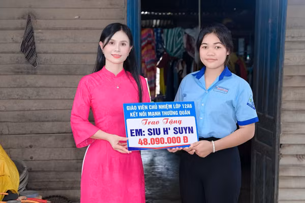 Cô giáo Hoàng Thị Diệu Loan trao phần quà của nhà hảo tâm hỗ trợ cho em Siu H’Suyn.