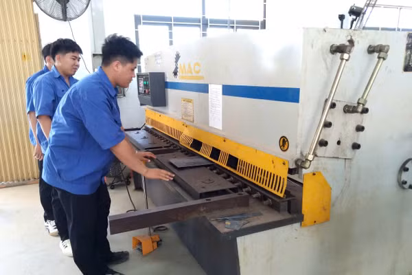 Sinh viên học tập trên máy cắt kim loại.