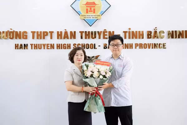 Nhà giáo Đặng Thị Bích Vân - Hiệu trưởng Trường THPT Hàn Thuyên chúc mừng em Lê Minh Đức.