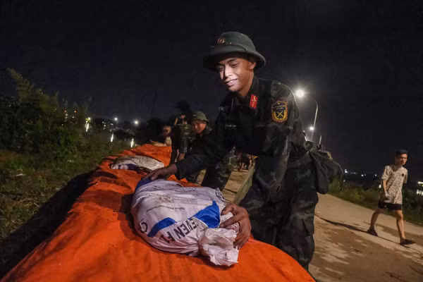Giáo viên cùng quân dân trắng đêm giữ đê chống lũ 