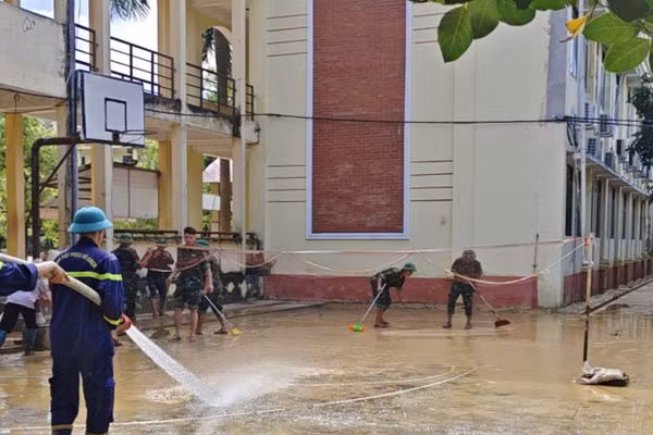 Cán bộ, chiến sĩ công an phối hợp cùng các thầy cô giáo dọn vệ sinh.
