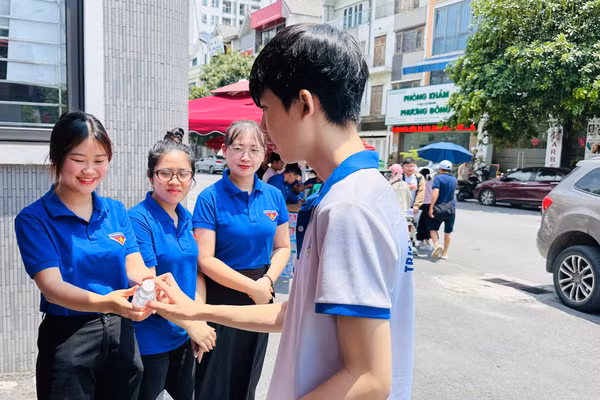 Thanh niên tình nguyện tặng nước uống cho thí sinh tại điểm thi Trường THCS Nguyễn Như Uyên (phường Yên Hòa).