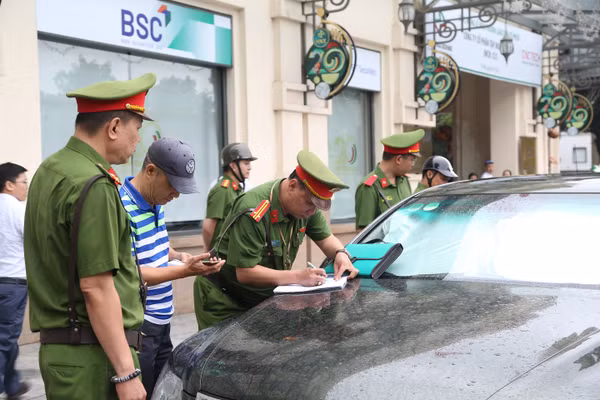 Công an phường Cửa Nam lập biên bản trường hợp xe ô tô dừng đỗ sai quy định. Ảnh: Đăng Chung