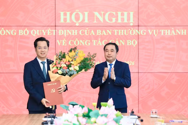 Bí thư Thành ủy Hà Nội Trần Đức Thắng trao quyết định và tặng hoa chúc mừng tân Trưởng Ban Tổ chức Thành ủy Hà Nội Vũ Đăng Định. Ảnh: QT