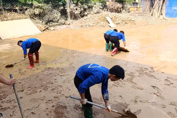 Sinh viên Trường Đại học Điện Lực dọn dẹp, hỗ trợ người dân khắc phục hậu quả sau mưa lũ.