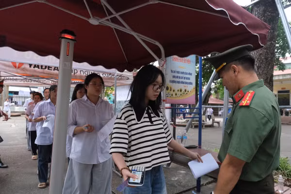 Thí sinh đi qua cửa từ có máy quét cầm tay của lực lượng chức năng.